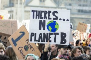 Demonstrators in the street with message There Is no Planet B on a placard.